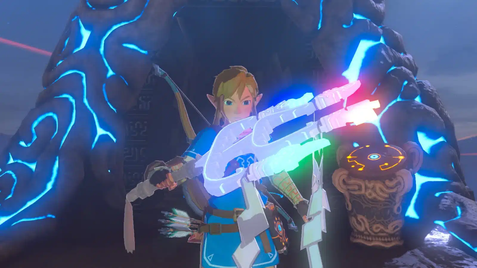 Link in his Champion's Tunic holding a glowing weapon in front of a Sheikah structure in Breath of the Wild