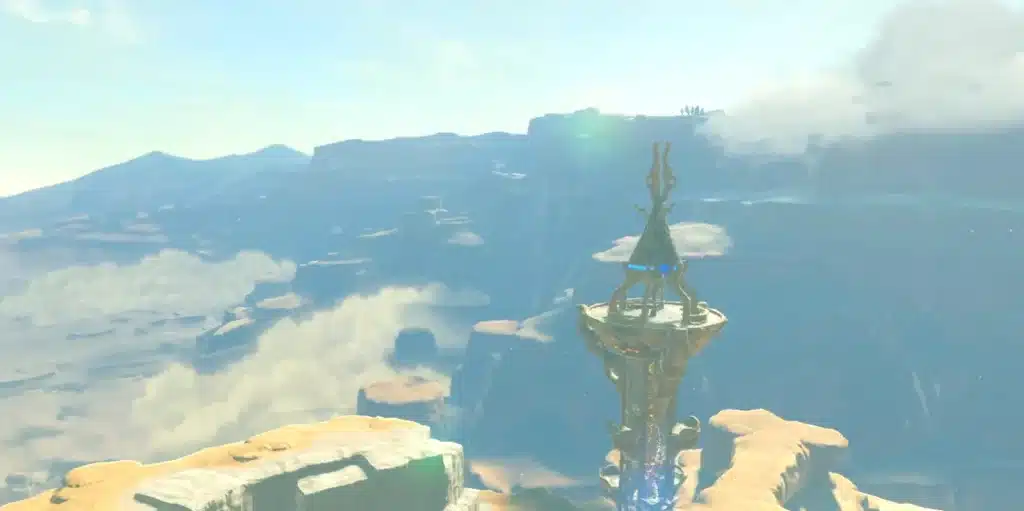 Sheikah Tower rising between rocky canyon cliffs above a sea of clouds in Breath of the Wild