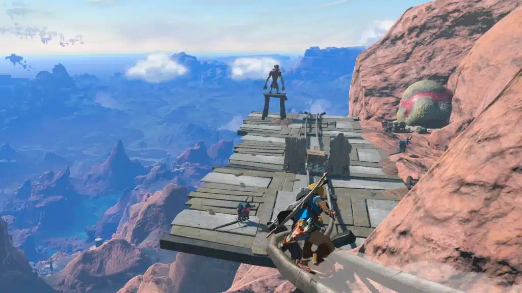Link on a wooden lookout platform built against red canyon cliffs high above Hyrule in Tears of the Kingdom
