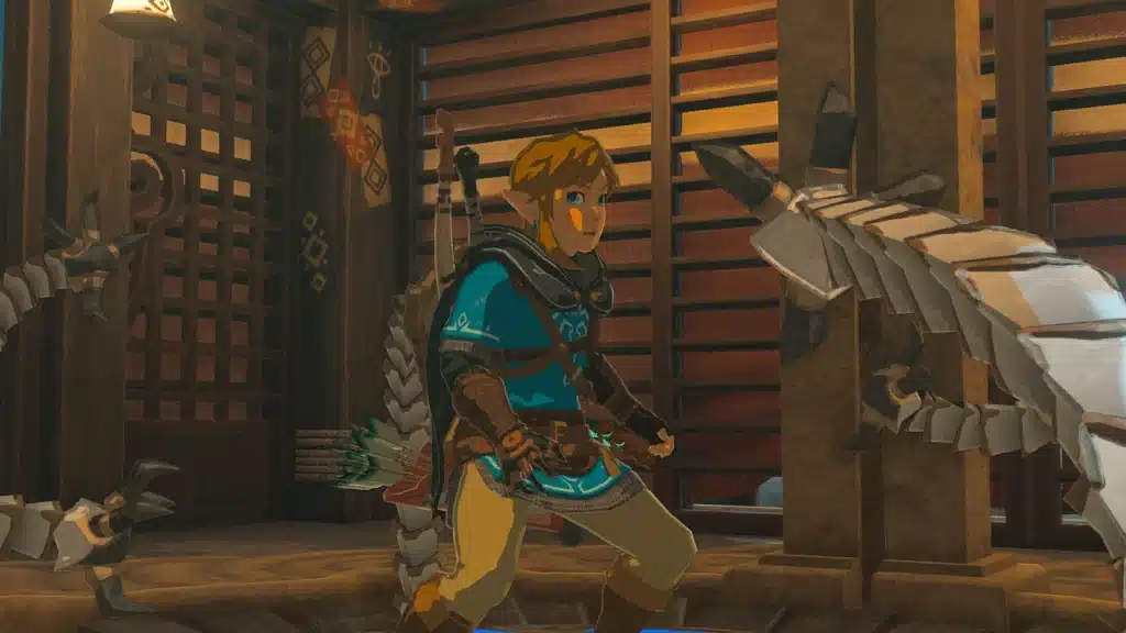 Link in a fighting stance with a fused weapon and a shield on his back inside a wooden room in Tears of the Kingdom