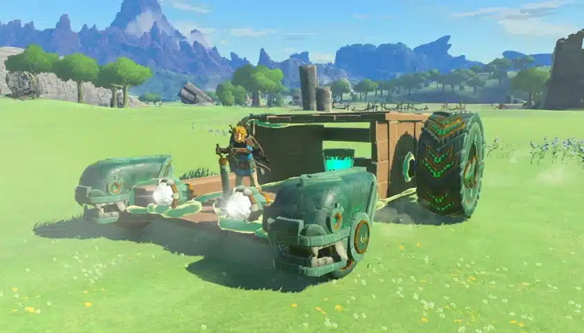 Link riding a vehicle built from Zonai devices and a large wheel in Tears of the Kingdom